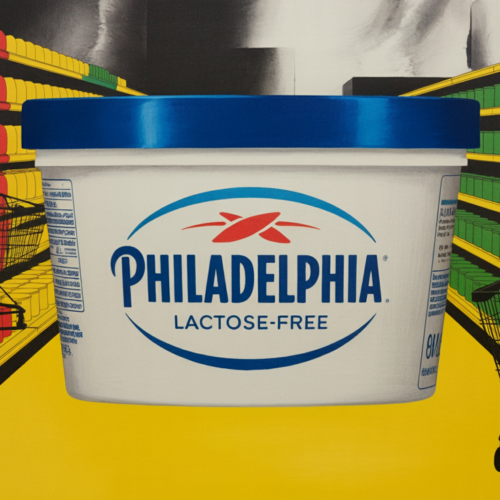 Philadelphia cream cheese block beside Cheez-It and Pringles snack packaging on retail shelf