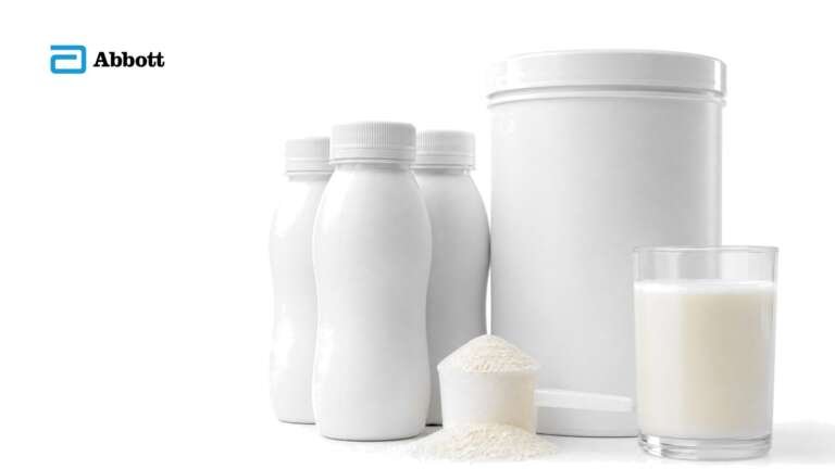 Plain white nutrition shake bottles, a powdered formula canister with a scoop and a glass of vanilla shake on white, with the Abbott logo