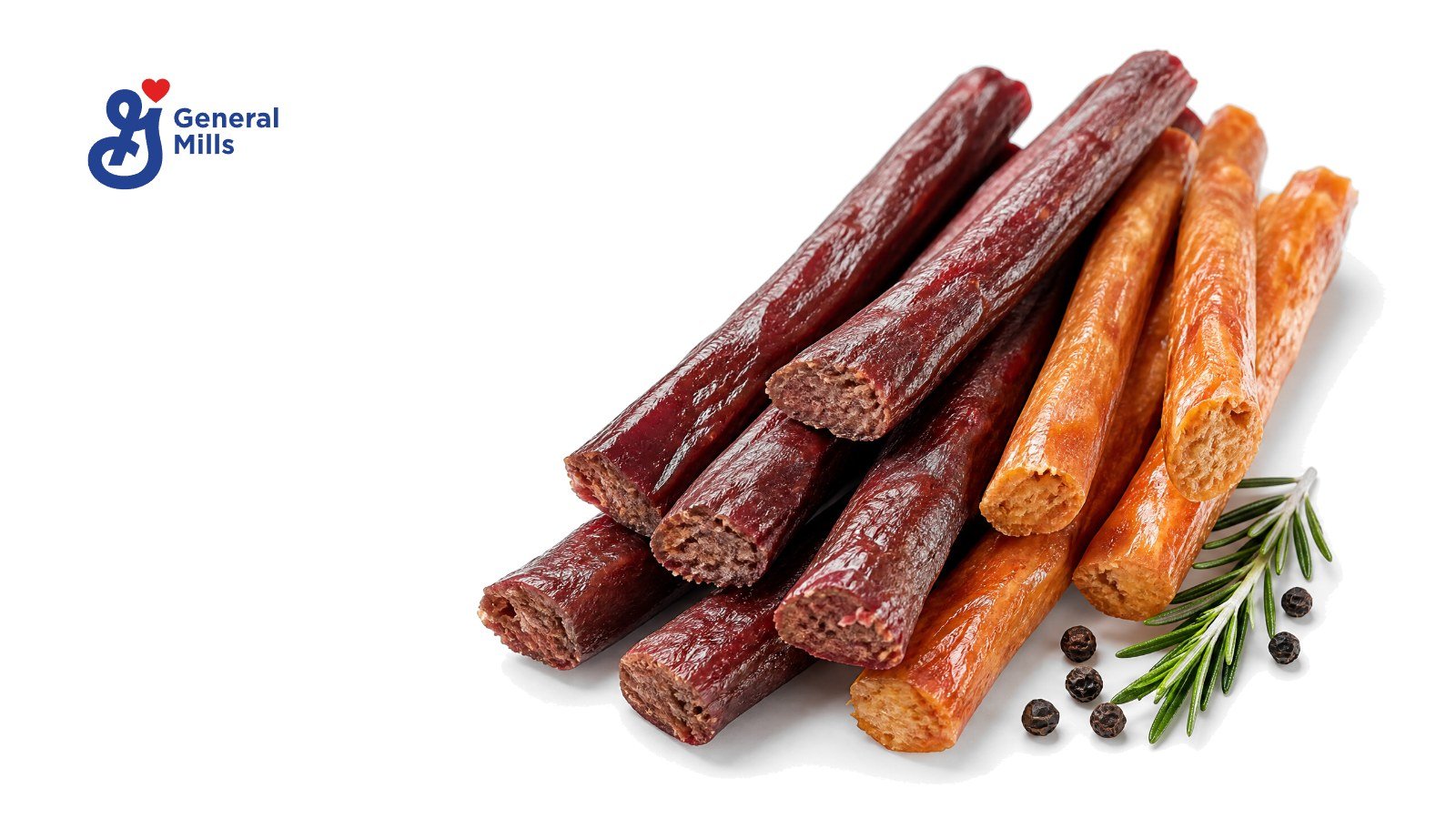 A fan of unwrapped beef and chicken meat sticks, some snapped in half, with rosemary and peppercorns on white, with the General Mills logo