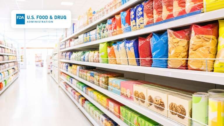 A bright grocery store snack and candy aisle with the U.S. Food and Drug Administration logo