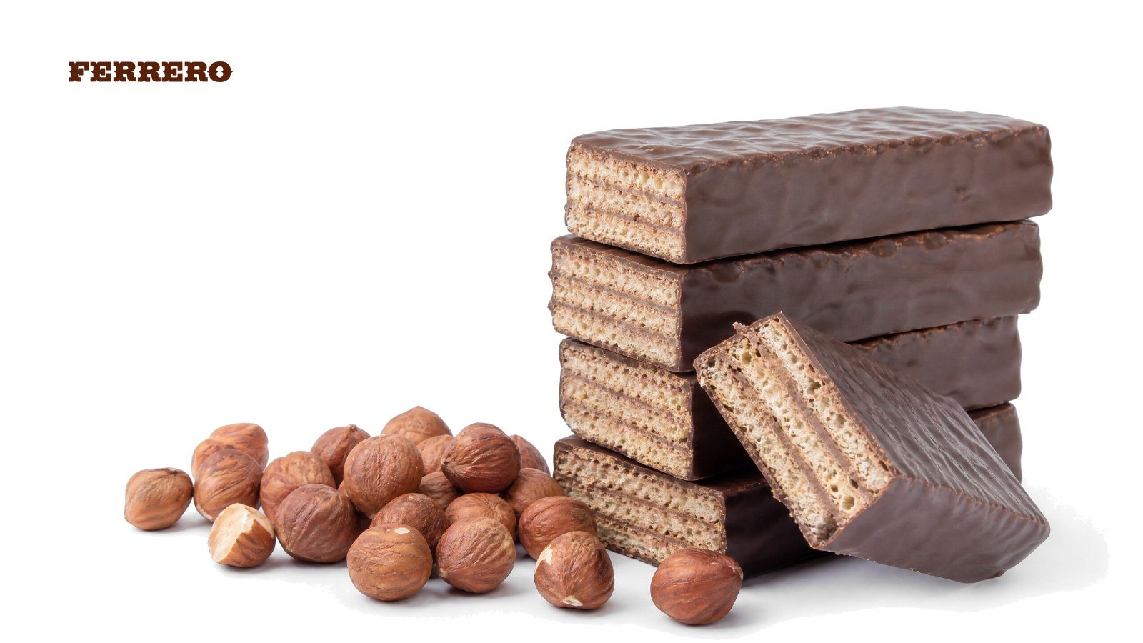 Chocolate-coated wafer protein bars, one snapped in half, beside roasted hazelnuts on white, with the Ferrero logo
