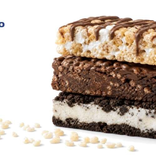 A stack of three protein bars, marshmallow crisp, brownie crisp and cookies and cream, on white, with the PepsiCo logo