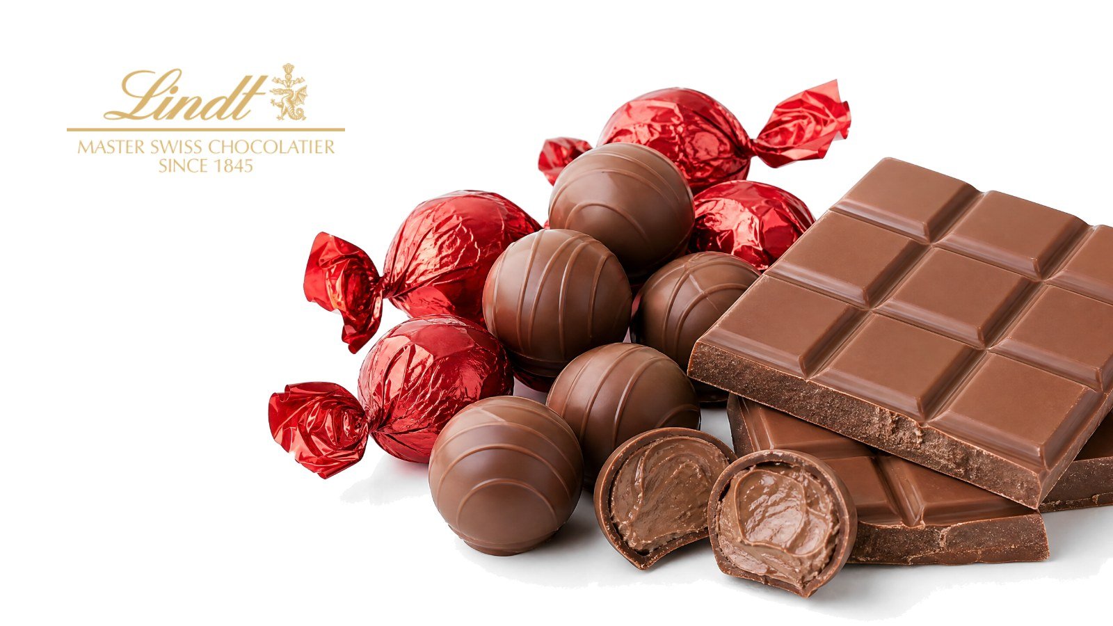 Red Lindt Lindor milk chocolate truffle bag and a gold-wrapped Lindt Excellence bar on a bright pure white studio background