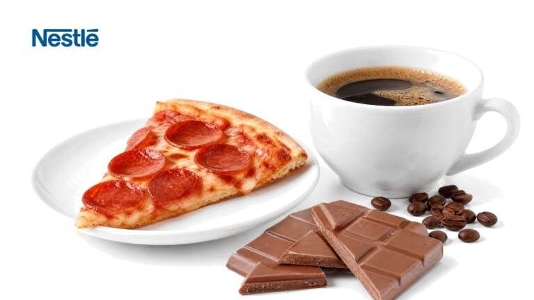 A cup of coffee with beans, a slice of pepperoni pizza and broken milk chocolate on white, with the Nestle logo