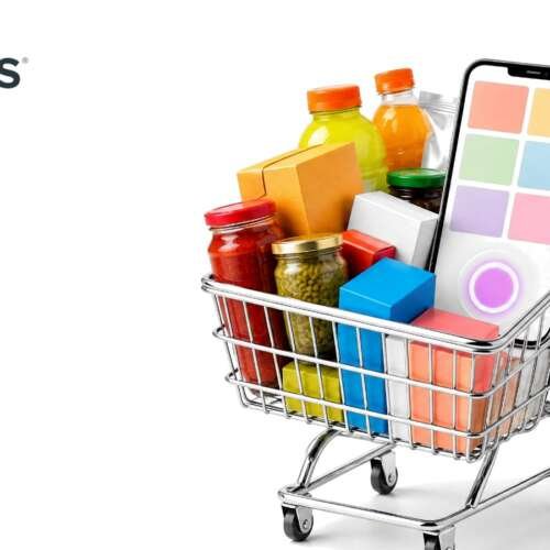 A chrome shopping cart full of colorful grocery items with a smartphone standing inside it, with the SPINS logo