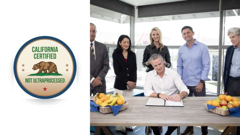 A concept "California Certified Not Ultraprocessed" seal beside Gov. Gavin Newsom signing AB 2244 at a table with fruit baskets