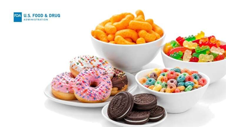 Bowls of cheese puffs, gummy candy and frosted cereal loops with sprinkle donuts and sandwich cookies on white, with the FDA logo