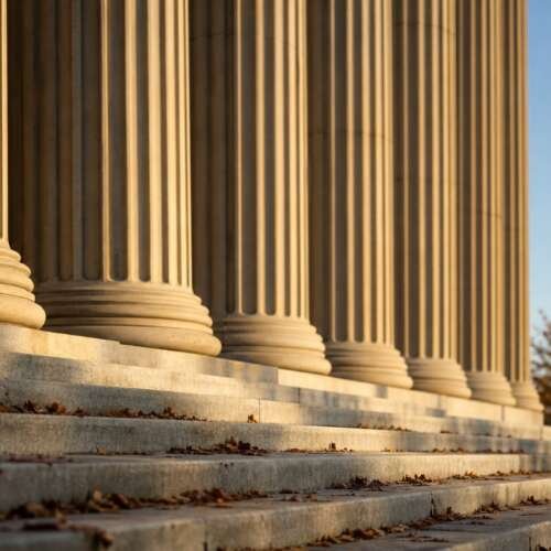 Columns and steps of a federal government building in Washington, D.C., with an American flag